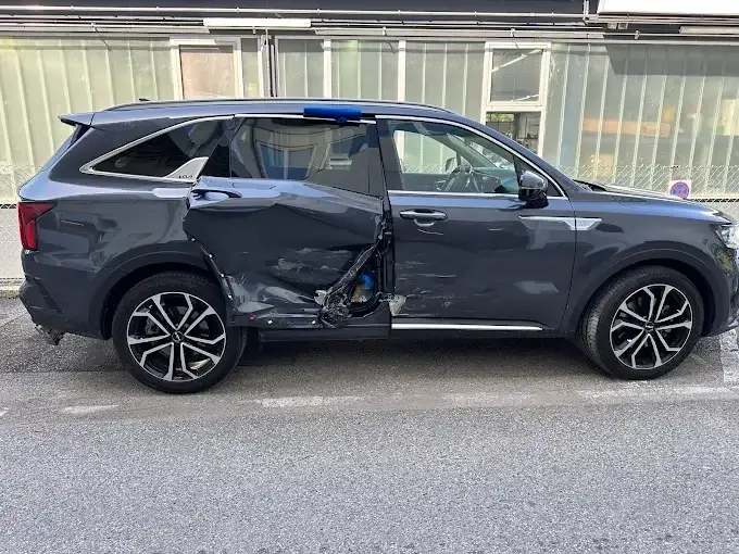 Dunkelgrauer Kia Sorento mit eingedrückter Fahrertür und verformtem Schweller nach einem Seitenaufprall
